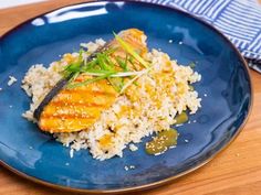 a blue plate topped with rice and fish