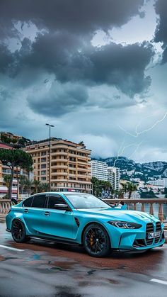 a blue car parked on the side of a road in front of a storm cloud