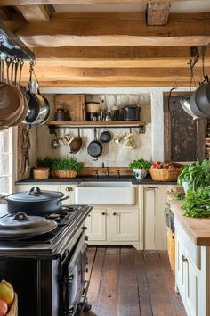 an old fashioned kitchen with pots and pans hanging from the ceiling over the stove