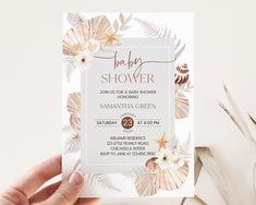 a baby shower is being held up in front of a white background with flowers and leaves