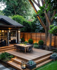 an outdoor patio with steps leading up to the dining room and deck area, surrounded by greenery