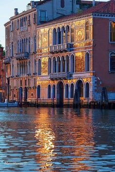 buildings along the water in venice, italy at sunset with reflections on the water surface