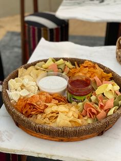 a basket filled with chips and salsa sitting on top of a table