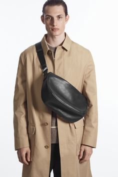 Debuting in the Autumn Winter menswear collection, this refined bag is crafted from premium chrome-free leather with a light layer of padding. It's designed in a subtle crescent shape that will tuck perfectly under your arm when worn crossbody and features silver-tone hardware, an internal slip pocket and a wide webbing strap that can be adjusted to your preference. Zip closureCOS supports responsible manufacturing via the Leather Working Group Shell: 100% Leather, Lining: 100% Organic cotton Height: 19.6cm, Depth: 12.5cm Winter Menswear, Crescent Shape, Webbing Strap, Black Leather Bags, Menswear Collection, Leather Working, Wallet Men, Wardrobe Essentials, Crescent