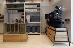 a coffee machine sitting on top of a wooden shelf in a room filled with boxes and containers