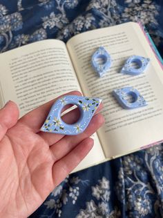 a person holding an open book and some magnets