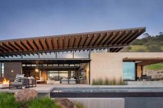 a modern house with an outdoor fireplace and seating area