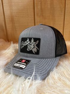 Guy's or Girl's choice: This hat comes in grey with black and pink with black. The design is engraved into the patch and not vinyl or any sort of sticker. The hat is adjustable snapback and the patch is vegan leather. Care Instructions: Machine wash Fabric: 50% Polyester, 25% Cotton and 25% Rayon 100% polyester mesh back Gray Baseball Cap With Logo Patch, Gray Hat With Logo Patch And Curved Brim, Gray Snapback Hat With Logo Patch And Curved Brim, Gray Trucker Baseball Cap With Flat Bill, Gray Casual Trucker Hat With Logo Patch, Gray Trucker Hat With Logo Patch, Gray Flat Brim Trucker Hat For Sports, Gray Trucker Hat With Logo Patch And Curved Bill, Gray Flat Bill Snapback Hat For Baseball Season