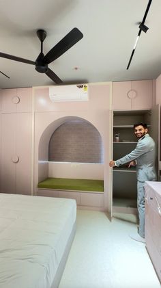 a man standing in front of a bed with a built - in pizza oven behind it