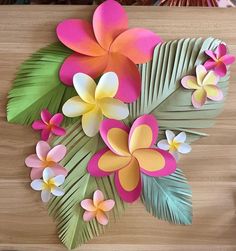 some paper flowers and leaves on a table