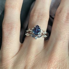 a woman's hand with a ring on it and a blue stone in the middle