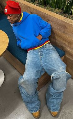 a man sitting on top of a wooden bench