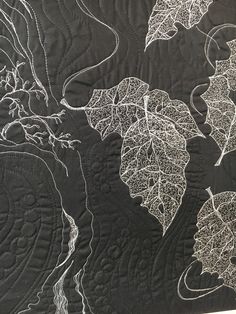 a black and white quilt with leaves on it