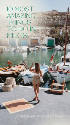 a woman standing on the dock next to boats