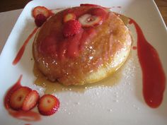 a pastry with strawberries on it sitting on a white plate