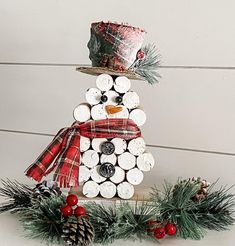 a snowman made out of wine corks with a hat and scarf on top