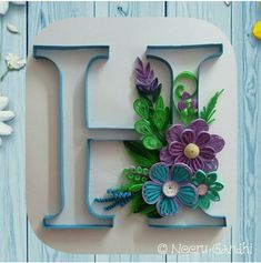 the letter h is decorated with flowers and leaves