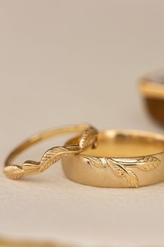 two gold wedding rings sitting next to each other