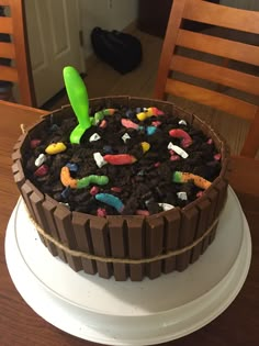 a birthday cake decorated to look like an alien in the middle of dirt and candy