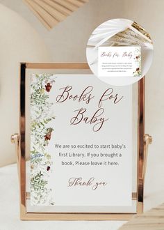 a sign that says books for baby and is next to a bed with white sheets