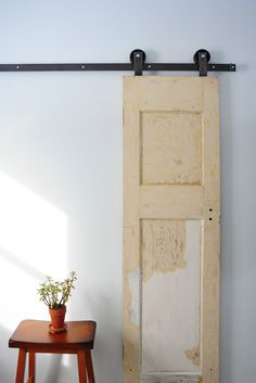 a potted plant sitting on top of a wooden stool next to an open door