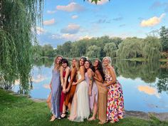 a group of women standing next to each other near a lake