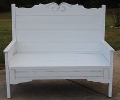 a white bench sitting on top of a sidewalk