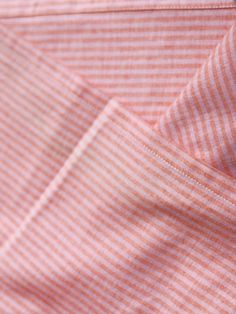 an orange and white striped shirt with buttons on the front, close up view to the chest