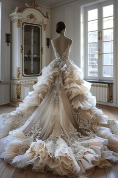 the back of a wedding dress on display in a room with white walls and wooden floors