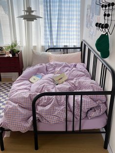 a bed in a room with a checkered comforter and pillows on top of it