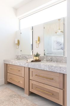 a bathroom with double sinks and two mirrors