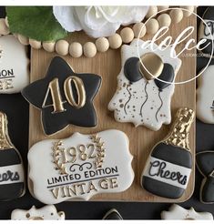 decorated cookies are displayed on a wooden tray