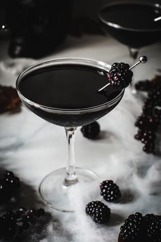 a glass filled with blackberries on top of a table