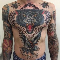 a man with tattoos on his chest has an eagle and wolf tattoo on his chest