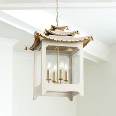 a light fixture hanging from the ceiling in a room with white walls and flooring