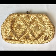 a gold beaded purse on a white surface