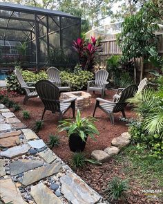 an outdoor patio area with chairs and tables in the center, surrounded by plants and rocks