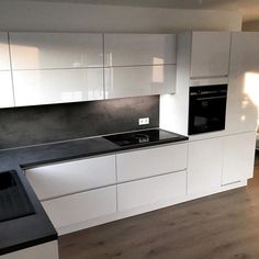 an empty kitchen with white cabinets and black counter tops is seen in this image, while the light shines through the window