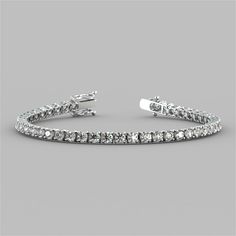 Spoil yourself or that someone special with this divine bracelet. Stunningly classic, 49 round cut Simulated Diamonds with a total weight of 8.67CTW radiate beautifully within a classic 4-prong setting. Enclosed by a box clasp to ensure your precious piece is always secure, this tennis bracelet is the perfect touch to any look.    8.67CTW Classic Round Cut Tennis Bracelet;  Stone Clarity: VVS-1;  Available in:14K White or Yellow Gold;  Length: 7 inches;  Model: B3557A; Classic Silver Tennis Bracelet With Prong Setting, Classic Diamond Cut Bracelet In Diamond White, White Gold Bracelets With Prong Setting, White Gold Bracelets With Prong Setting And Round Cut, Elegant Sterling Silver Bracelet With Prong Setting, Classic Tennis Bracelet With Prong Setting, Classic Silver Tennis Bracelet With Single Cut Diamonds, Classic Diamond Cut Tennis Bracelet For Anniversary, Classic Tennis Bracelet In Diamond White With Diamond Cut