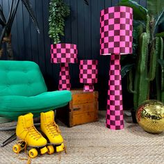 some yellow roller skates are sitting on the floor next to a green chair and potted plants