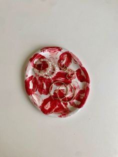 a red and white plate sitting on top of a table next to a pair of scissors