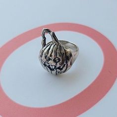 Product Description: Introducing our Sterling Silver Scary Jack-O'-Lantern Pumpkin Ring - the perfect addition to any Halloween fan's collection! This handcrafted ring is made from high-quality 925 silver and features immaculate detail, making it a unique and eye-catching accessory. The anatomically accurate design of the scary jack-o'-lantern pumpkin adds a touch of gothic and punk aesthetic to the ring.  Highlights: - This ring is handmade from 925 silver, making it a durable and long-lasting accessory.  - The anatomically accurate design of the scary jack-o'-lantern pumpkin adds a unique touch to the ring.  - The gothic and punk aesthetic of the ring makes it perfect for Halloween, as well as everyday wear.  - This item is dispatched from a small business in Greece, ensuring that your p Vintage Skull Ring For Halloween Collectible, Handmade Vintage Halloween Rings, Unique Metal Rings For Halloween, Handmade Vintage Rings For Halloween, Vintage Adjustable Skull Ring For Halloween, Adjustable Vintage Skull Ring For Halloween, Handmade Gothic Skull Ring For Halloween, Skull Shaped Ring As Halloween Gift, Gothic Collectible Rings For Halloween