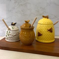 three ceramic honey jars with bees on them