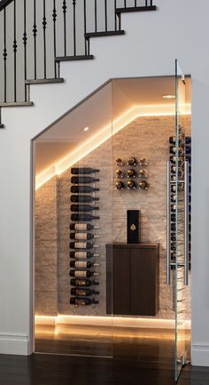 a wine cellar in the middle of a room with stairs leading up to an upper level