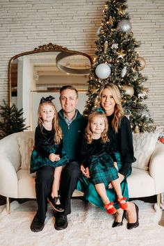 a family sitting in front of a christmas tree