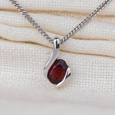 Elegant sterling silver contemporary pendant set with an elegant natural oval red garnet from Mozabique gemstone with an approximate ct weight of 0.55ct This elegant pendant is suitable to wear for daytime or evening wear. It is supplied on an 18inch sterling silver chain. Both the pendant and chain are finished with a commercial grade rhodium plate to give a high quality shine finish. Supplied in an Ojewellery presentation box, within a ribbon handled gift bag, complete with product information Red Garnet Oval Pendant Necklace, Oval Garnet Necklaces For Anniversary, Oval Garnet Necklace For Anniversary, Ruby Necklace With Polished Finish As Gift, Polished Ruby Necklace For Gift, Ruby Necklace With Polished Finish For Gift, Formal Oval Garnet Pendant Jewelry, Oval Garnet White Gold Jewelry, Red Sterling Silver Birthstone Necklace For Anniversary