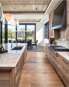 a kitchen with wooden cabinets and marble counter tops, along with an island in the middle