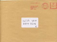 an envelope with a handwritten note on the front and back of it that says wish you were here x