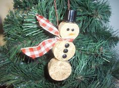 a wine cork snowman ornament hanging from a christmas tree