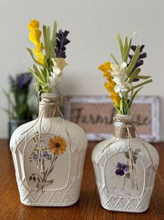 two vases with flowers are sitting on a table